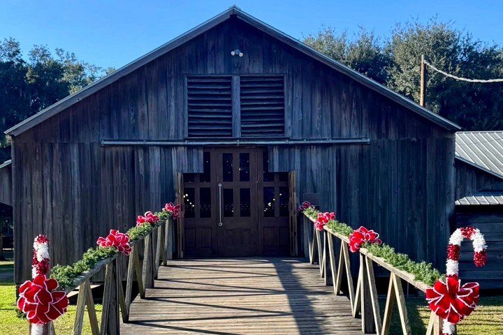Wooden barn with Christmas decorations on a ramp leading to the entrance.