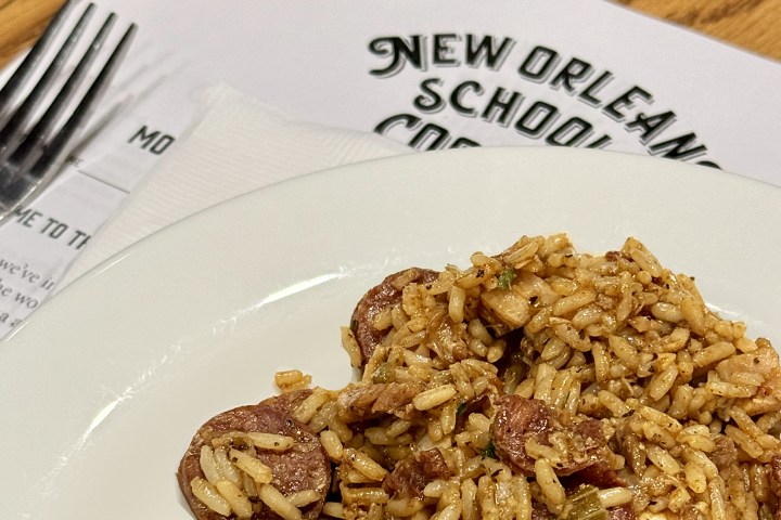 Plate of rice and sausage dish on a table with New Orleans menu.