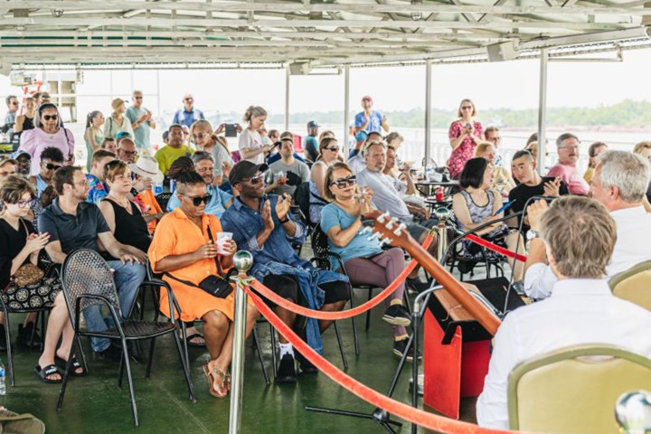 Audience on a boat watching live music performance, outdoor setting.
