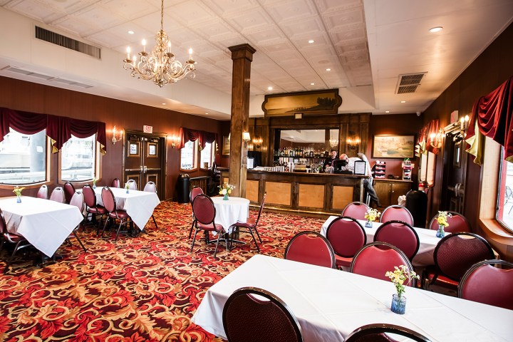 Elegant restaurant interior with red carpet, chandelier, and bar.